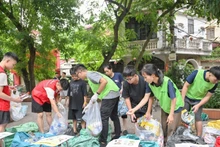 住民に有機ごみと無機ごみの分別方法を指導するTagomのメンバー