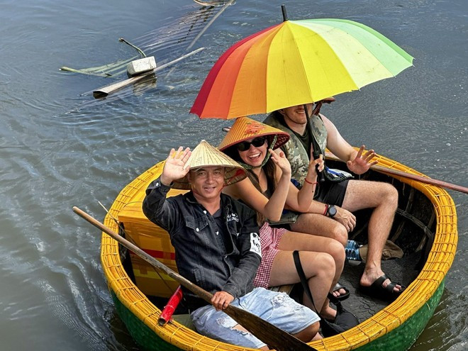 ダナン市ホイアン・ドン区カムタイン観光村でバスケットボート体験を楽しむ外国人観光客（写真：VNA）