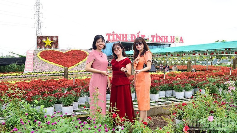 ハートを背景にポーズをとる来場者たち。約70平方メートルに及ぶ巨大な花のハートは、1,600鉢の生花で作られている。