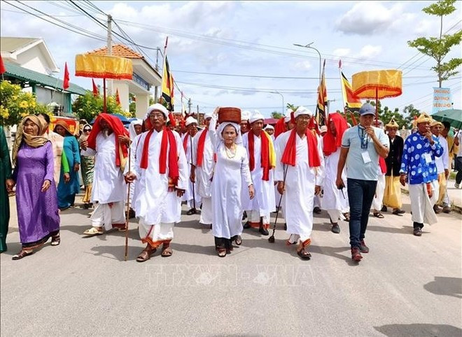 カテ祭り2025で、チャム共同体のバラモン聖職者が聖なる衣装を運ぶ行列を先導する様子（写真：VNA）