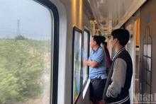 車両の窓越しに景色を楽しむ乗客