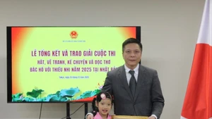 コンテスト参加者のキム・チャ・ミーさん（左）が、在日ベトナム大使館から証明書を受け取っている様子（写真：VNA）