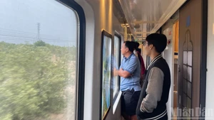 車両の窓越しに景色を楽しむ乗客