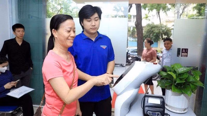 ハノイ市クアナム区の公共行政サービス窓口でAIロボットを利用する市民