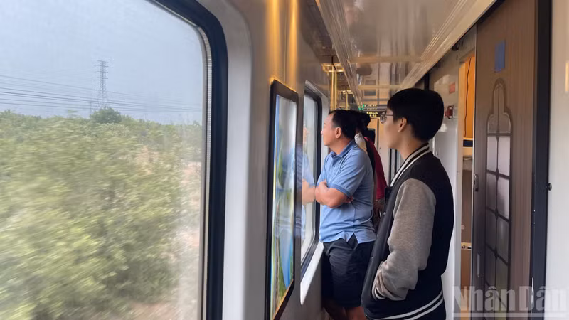 車両の窓越しに景色を楽しむ乗客