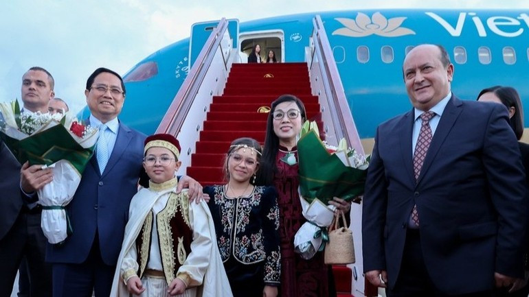 ウアリ・ブーメディアン空港で歓迎を受けるファム・ミン・チン首相と夫人（写真：VGP）