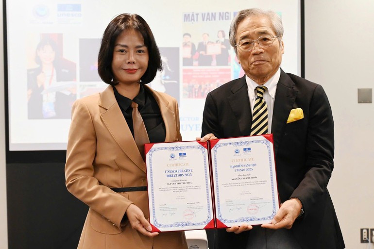 グエン・ティ・トゥ・ホアイ氏が、日本ユネスコ協会連盟の鈴木佑司理事長から表彰状を受け取る。