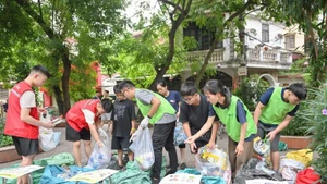 住民に有機ごみと無機ごみの分別方法を指導するTagomのメンバー