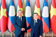 トー・ラム書記長（左）とラオス国民議会のサイソンポーン・ポムヴィハーン議長が、12月1日にビエンチャンで会談した。（写真：VNA）